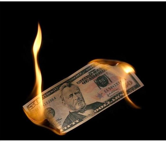 $50 bill being burned' flames on both ends